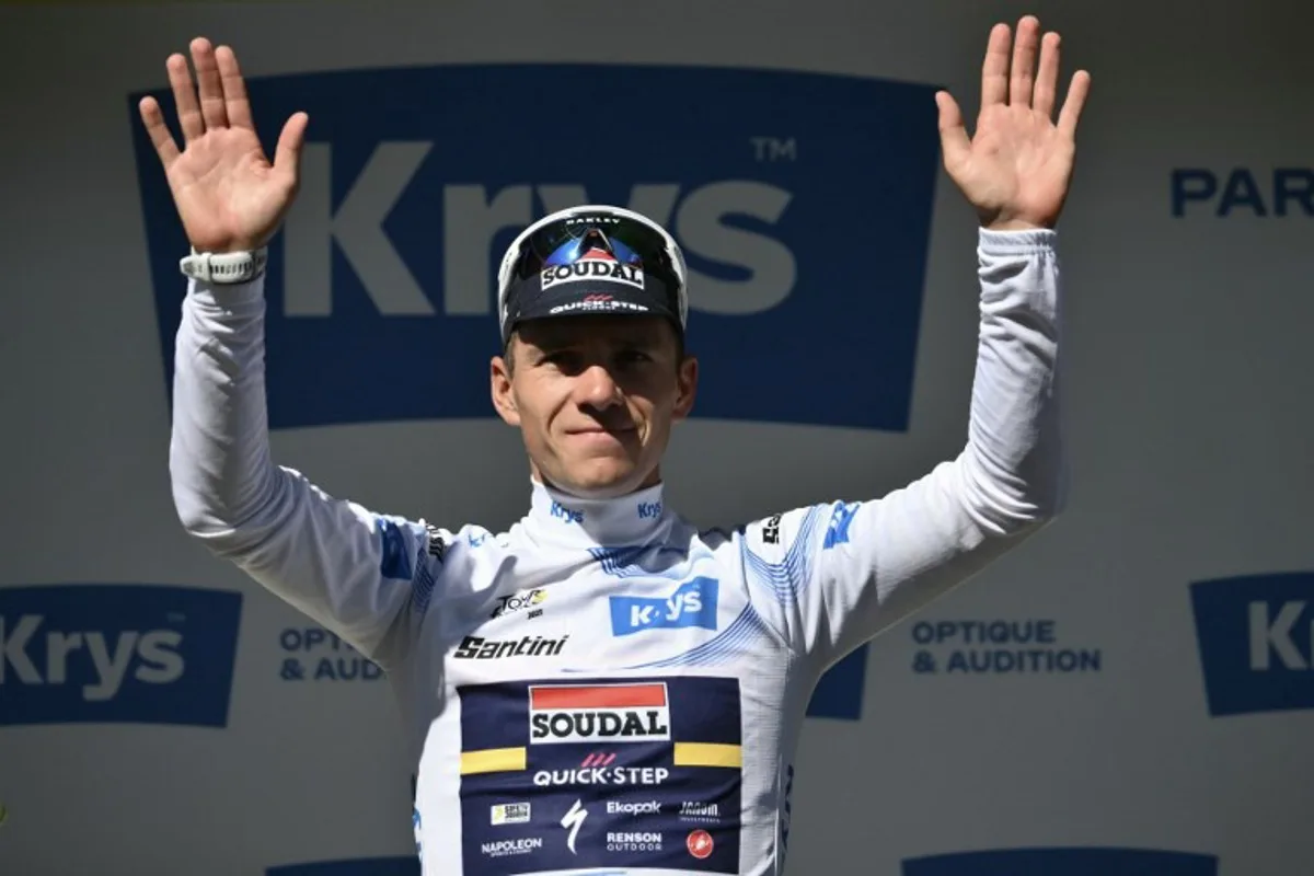 Soudal Quick-Step team's Belgian rider Remco Evenepoel celebrates on the podium with the best young rider's white jersey after the 6th stage of the 112th edition of the Tour de France cycling race, 201.5 km between Bayeux and Vire Normandie, Northwestern France, on July 10, 2025. Marco BERTORELLO / AFP