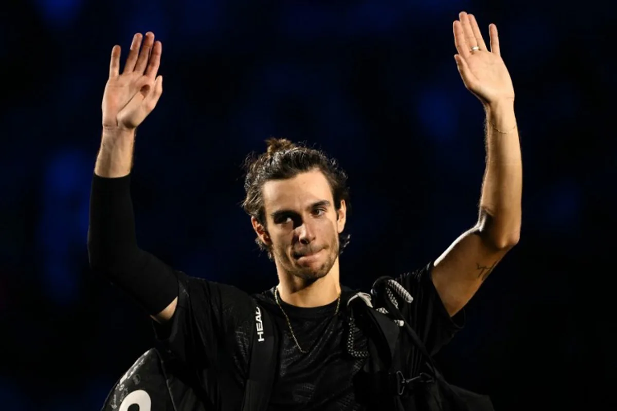 Italy's Lorenzo Musetti waves as he leaves the court after being defeated by Spain's Carlos Alcaraz at the ATP Finals tennis tournament in Turin on November 13, 2025. Marco BERTORELLO / AFP