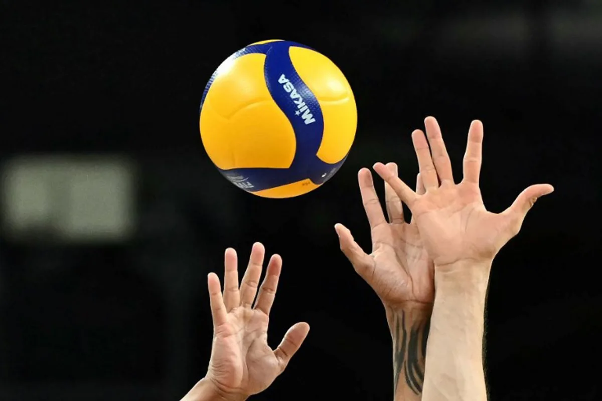 Brazil's #28 Darlan Ferreira Souza (L) and Brazil's #23 Flavio Resende Gualberto try to block the ball with their hands during the volleyball men's quarter-final match between USA and Brazil during the Paris 2024 Olympic Games at the South Paris Arena 1 in Paris on August 5, 2024.  Natalia KOLESNIKOVA / AFP