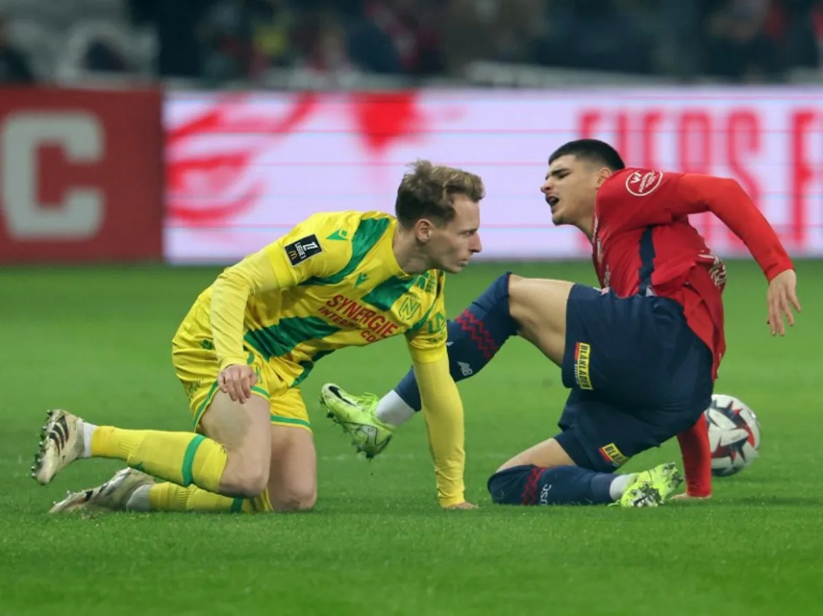 Lille's Belgian forward #19 Matias Fernandez-Pardo (R) and Nantes' French midfielder #08 Johann Lepenant fight for the ball during the French L1 football match between Lille LOSC and FC Nantes at Stade Pierre-Mauroy in Villeneuve-d'Ascq, northern France, on January 4, 2025.  FRANCOIS LO PRESTI / AFP