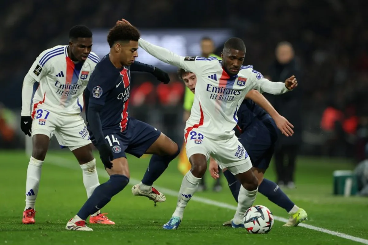 Lyon's Angolan defender #22 Clinton Mata (C) fights for the ball with Paris Saint-Germain's Portuguese midfielder #87 Joao Neves (R) and Paris Saint-Germain's French midfielder #14 Desire Doue (2L) during the French L1 football match between Paris Saint-Germain and Olympique Lyonnais at the Parc des Princes stadium in Paris on December 15, 2024.  FRANCK FIFE / AFP