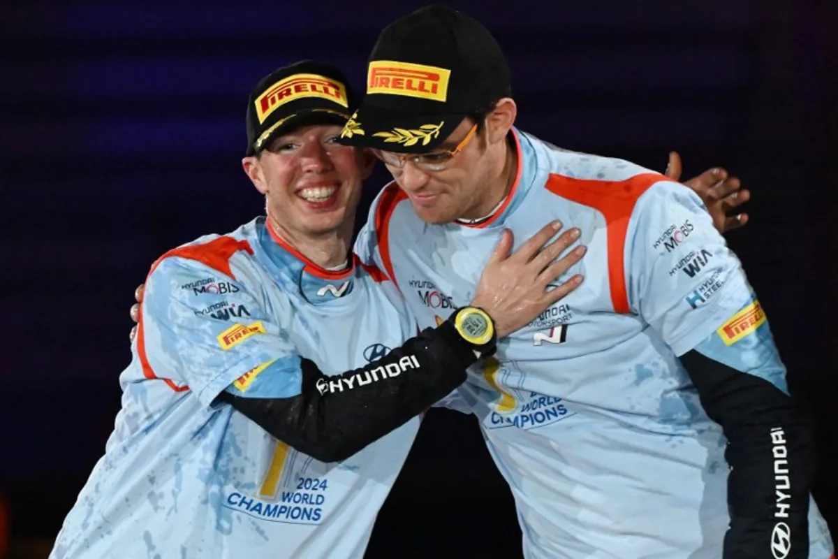 Thierry Neuville (R) and his co-driver Martijn Wydaeghe (L) of Belgium celebrate their World Champion on the podium at the Toyota stadium during the Rally Japan, the 13th and final round of 2024 FIA World Rally Championships, in Toyota city on November 24, 2024.   Toshifumi KITAMURA / AFP