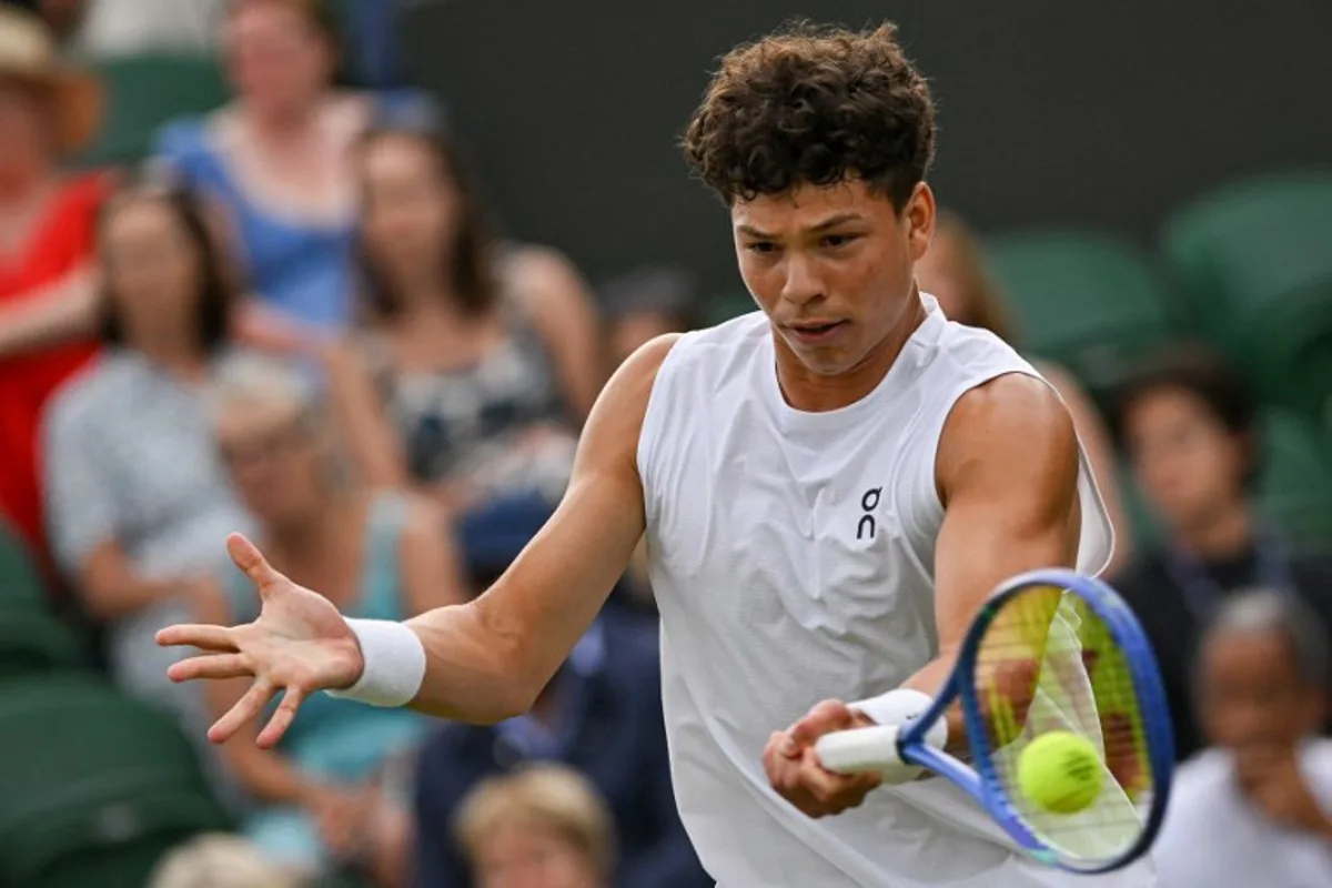 US Ben Shelton plays a forehand return to Australia's Rinky Hijikata during their men's singles second round tennis match on the fourth day of the 2025 Wimbledon Championships at The All England Lawn Tennis and Croquet Club in Wimbledon, southwest London, on July 3, 2025. Glyn KIRK / AFP