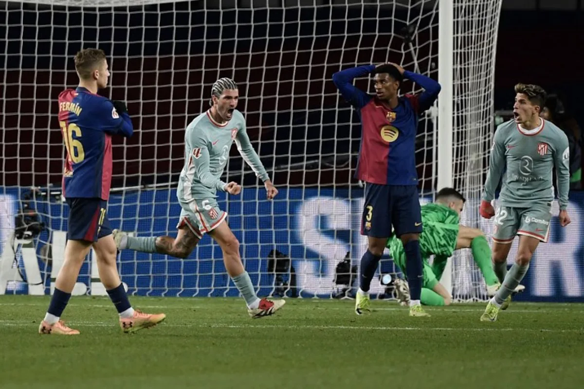 Atletico Madrid's Argentine midfielder #05 Rodrigo De Paul (2L) celebrates scoring their first goal during the Spanish league football match between FC Barcelona and Club Atletico de Madrid at the Estadi Olimpic Lluis Companys in Barcelona on December 21, 2024.  Josep LAGO / AFP