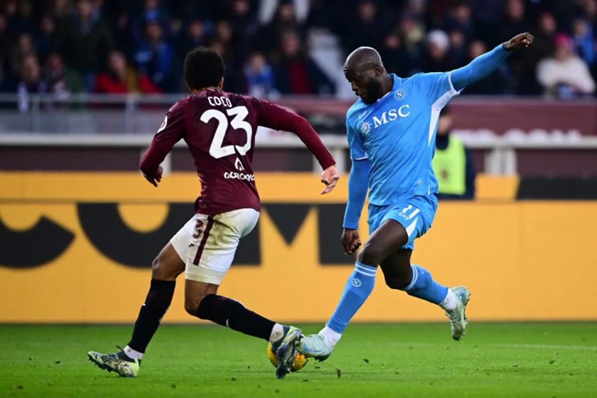 Napoli's Belgian forward #11 Romelu Lukaku (R) takes a shot on goal in front of Torino's Equatorial Guinea defender #23 Saul Basilio Coco-Bassey Oubina (L) during the Italian Serie A football match Torino vs Napoli at the "Stadio Grande Torino" in Turin on December 1, 2024.   MARCO BERTORELLO / AFP