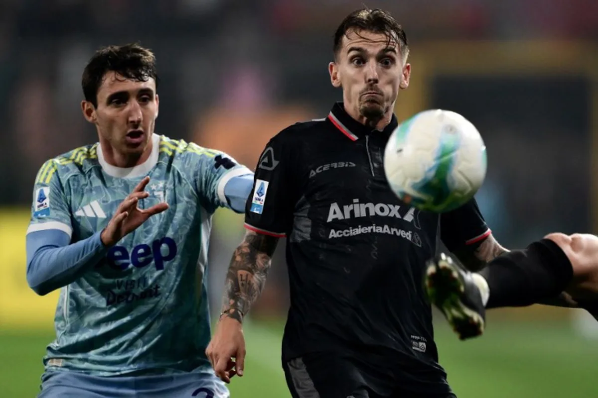 Juventus' Italian defender #27 Andrea Cambiaso (L) fights for the ball with Cremonese's Belgian midfielder #27 Jari Vandeputte during the Italian Serie A football match between Cremonese and Juventus at the Giovanni Zini Stadium in Cremona on November 1, 2025.   MARCO BERTORELLO / AFP