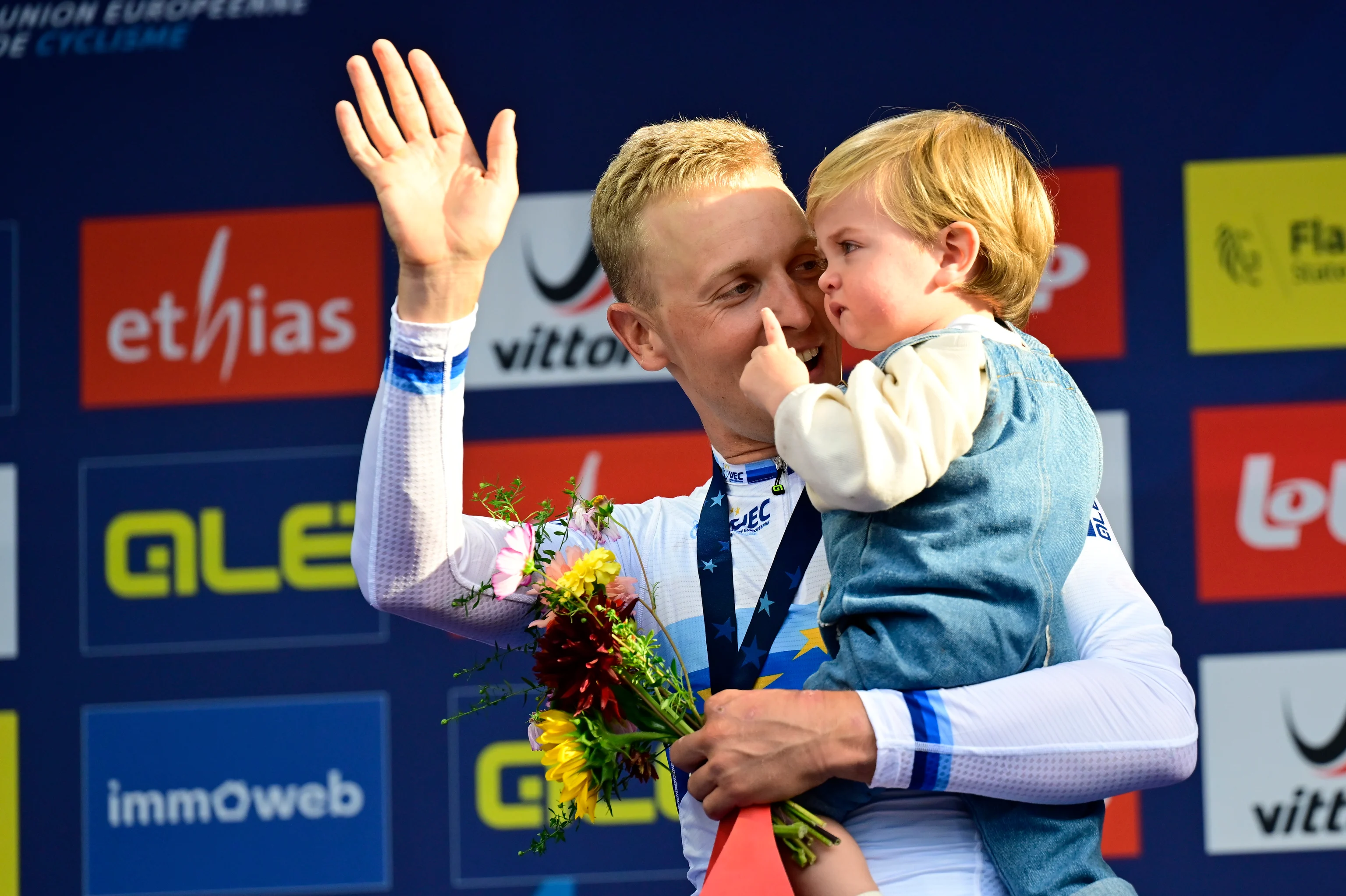 Winner European champion Belgian Tim Merlier celebrates on the podium with his new shirt and his son Jules at the Men's Elite Road Race at the European Championship 2024, in Hasselt, Sunday 15 September 2024. The UEC Road European Championships 2024 will take place from 11 to 15 september in Limburg, Belgium. BELGA PHOTO DIRK WAEM