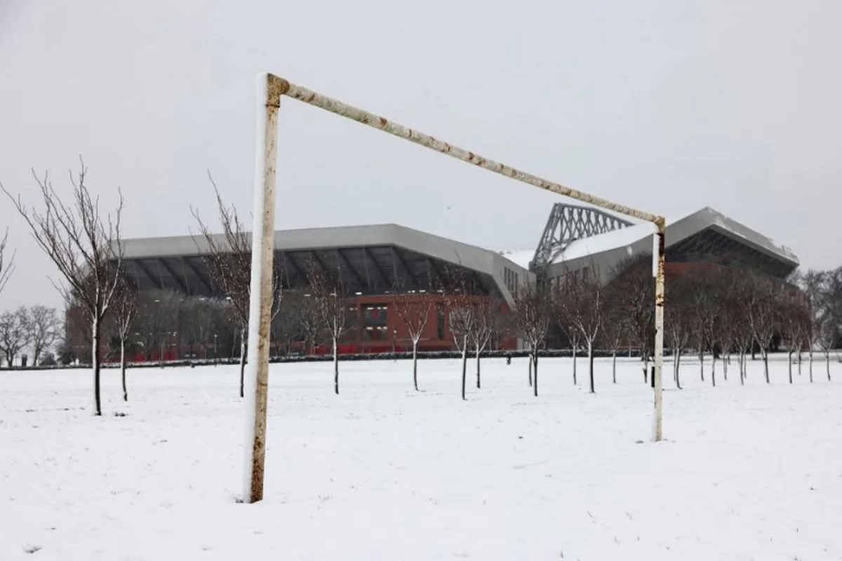 A photograph taken on January 5, 2025 shows Anfield stadium in Liverpool, north west England, covered in snow ahead of the the English Premier League football match between Liverpool and Manchester United, as heavy snow across parts of England are set to cause disruption. An amber weather warning -- the second most serious -- for snow and freezing rain was in place for much of Wales, central England and parts of northwestern England. Darren Staples / AFP