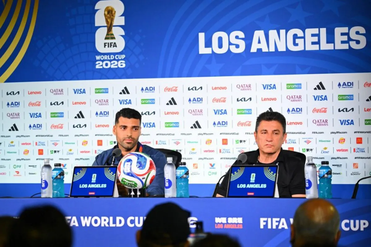 Iran's head coach Amir Ghalenoei (R) gives a press conference next to Iran's forward #09 Mehdi Taremi at Los Angeles Stadium in Inglewood on June 14, 2026, on the eve of the 2026 World Cup football match between Iran and New Zealand. Patrick T. FALLON / AFP