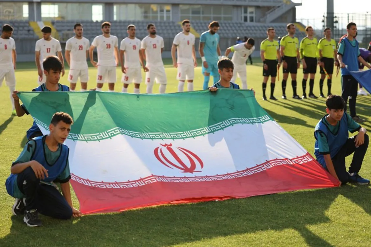 Iran's players stand behind the flag of Iran for photographers before the start of an international  friendly football match between Iran and Gambia, in Antalya, southern Turkey, on May 29, 2026, as part of the team's preparation for the upcoming football World Cup.  Oner SAN / AFP