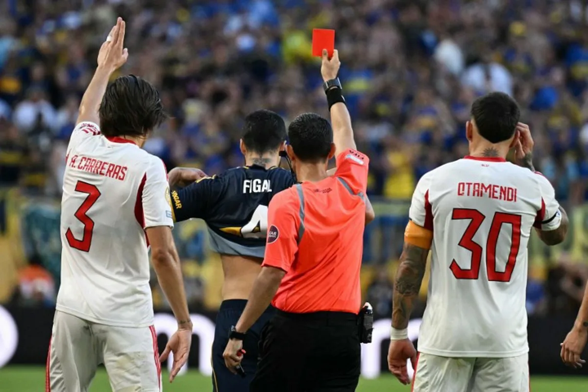 Mexican referee Cesar Ramos shows a red card to Boca Juniors' Argentine defender #04 Nicolas Figal (C-L) during the FIFA Club World Cup 2025 Group C football match between Argentina's Boca Juniors and Portugal's Benfica at the Hard Rock stadium in Miami on June 16, 2025. Chandan Khanna / AFP