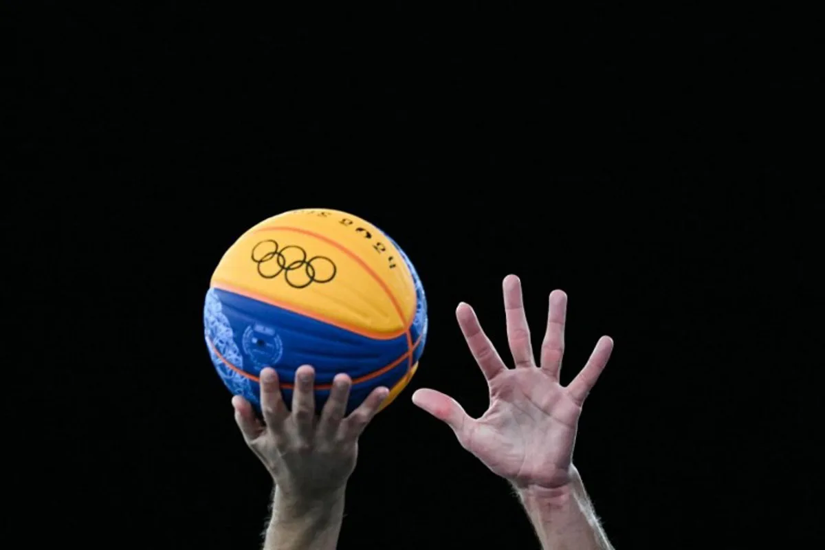 Players try to grab the ball in the men's 3x3 basketball play-in games between Serbia and France during the Paris 2024 Olympic Games at La Concorde in Paris on August 4, 2024. Luis ROBAYO / AFP