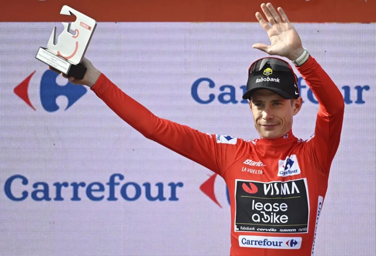 The overall leader Team Visma-Lease a bike's Danish rider Jonas Vingegaard celebrates on the podium wearing the red jersey after the tenth stage of the Vuelta a Espana cycling tour, a 168 km race between Sendaviva Natural Park in Arguedas and El Ferial Larra Belagua in Isaba, on September 2, 2025. Ander GILLENEA / AFP