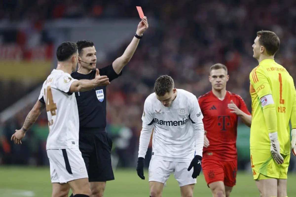 German referee Harm Osmers shows a red card to Bayern Munich's German goalkeeper #01 Manuel Neuer during the German Cup (DFB Pokal) round of 16 football match FC Bayern Munich v Bayer Leverkusen in Munich, southern Germany, on December 3, 2024.  Michaela STACHE / AFP