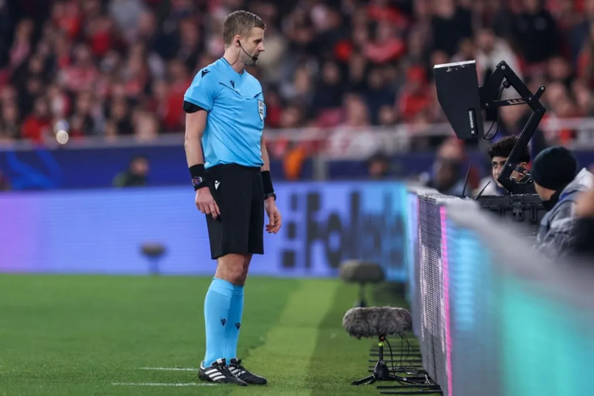 Referee Glenn Nyberg checks the VAR before awarding Benfica a penalty during the UEFA Champions League knockout phase play-off second leg football match between SL Benfica and AS Monaco at Luz stadium in Lisbon on February 18, 2025.  FILIPE AMORIM / AFP