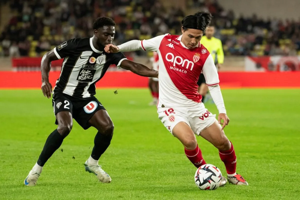 Monaco's Japanese forward #18 Takumi Minamino (R) fights for the ball with Angers' Haitian defender #02 Carlen Harcus during the French L1 football match between AS Monaco and SCO Angers at the Louis II Stadium (Stade Louis II) in the Principality of Monaco on November 1, 2024.  MIGUEL MEDINA / AFP