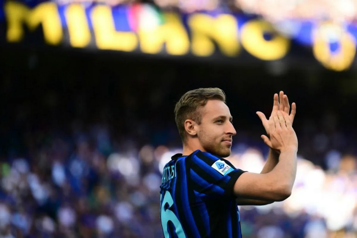 Inter Milan's Italian midfielder #16 Davide Frattesi applauds supporters as Inter Milan's players perpare to celebrate their 21st scudetto (Italian Championship victory) at San Siro stadium after the Italian Serie A football match between Inter Milan and Hellas Verona in Milan, on May 17, 2026. Marco BERTORELLO / AFP