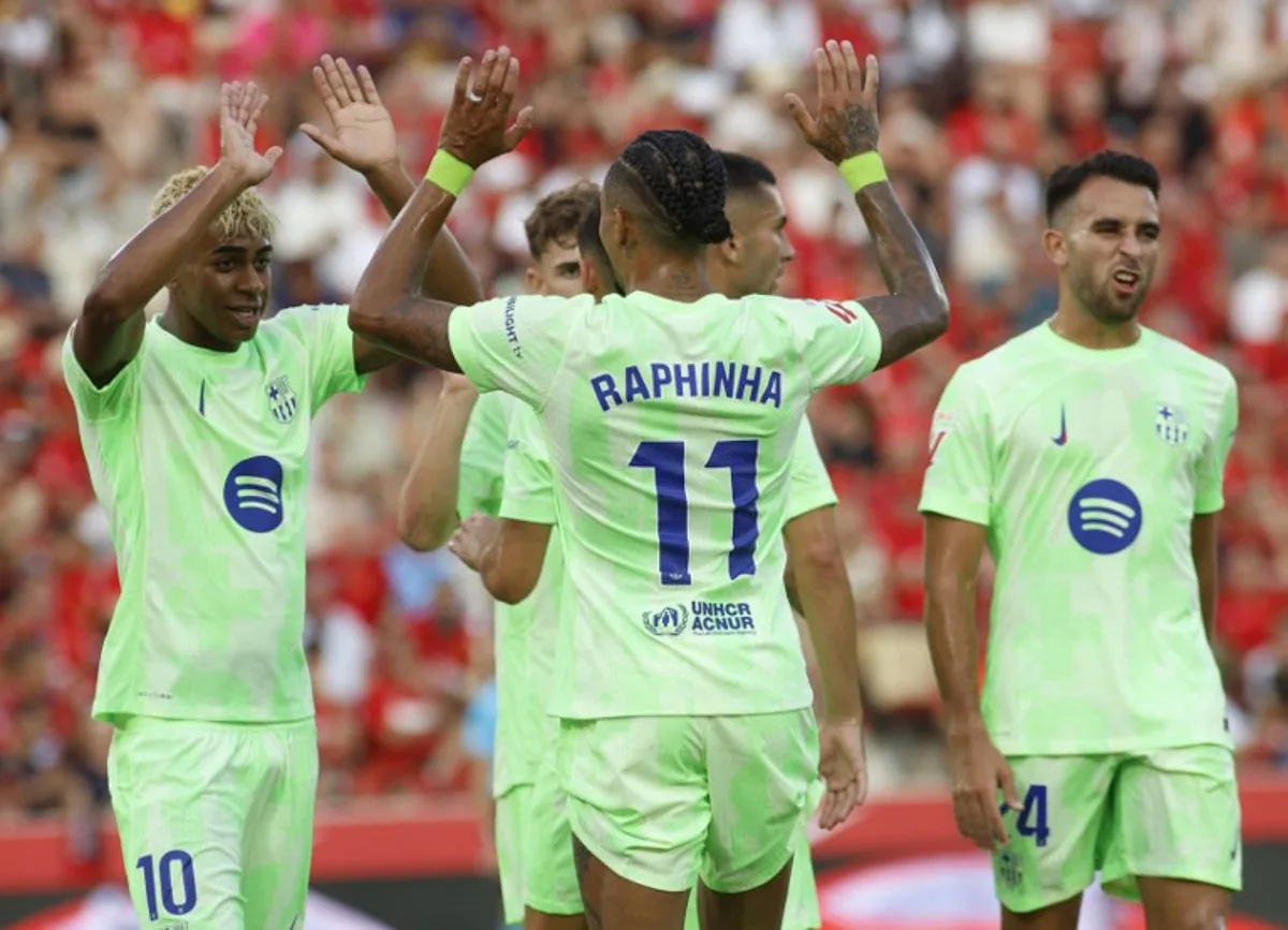 Barcelona's Brazilian forward #11 Raphinha celebrates with Barcelona's Spanish forward #10 Lamine Yamal after scoring the opening goal during the Spanish league football match between RCD Mallorca and FC Barcelona at Mallorca Son Moix Stadium in Palma de Mallorca on August 16, 2025.  JAIME REINA / AFP