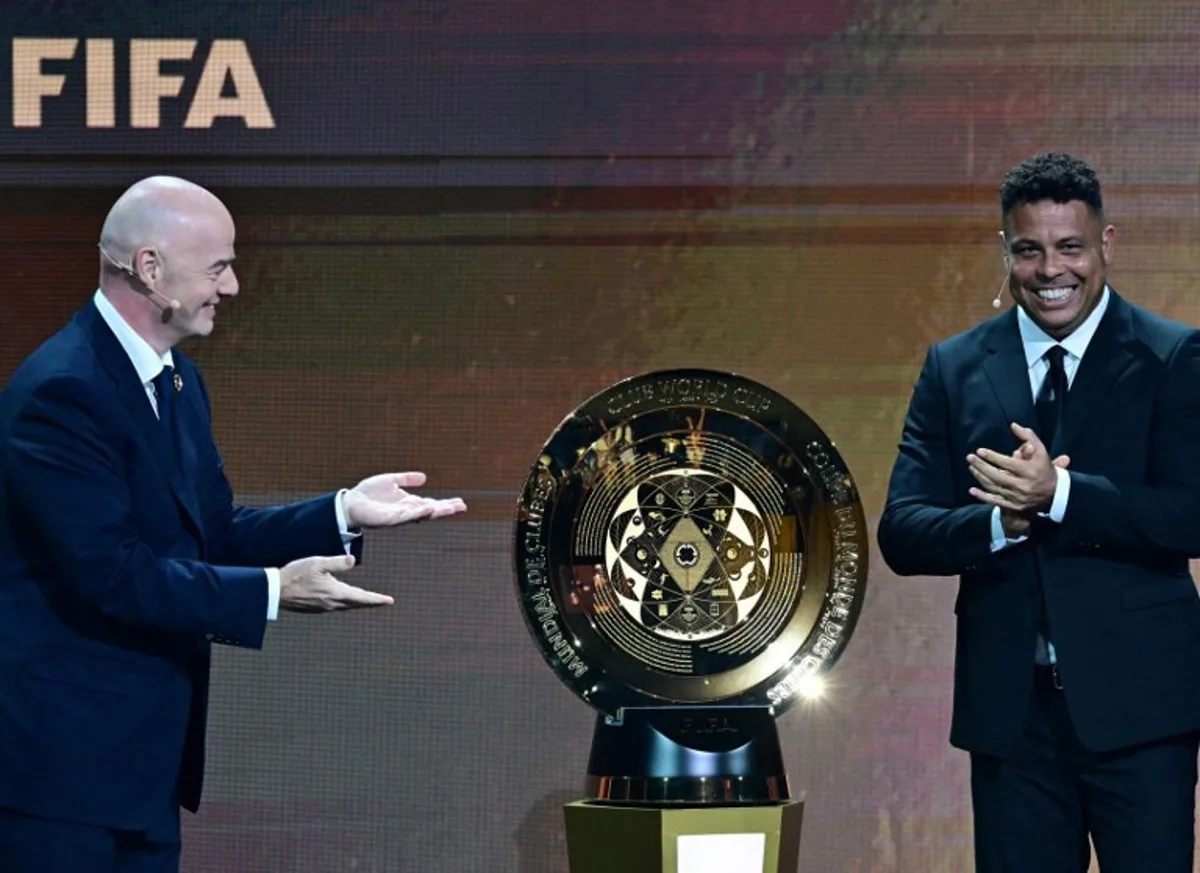 FIFA President Gianni Infantino (L) and Brazilian former soccer player Ronaldo unveil the trophy during the 2025 FIFA Club World Cup Draw ceremony in Miami on December 5, 2024.  Giorgio VIERA / AFP