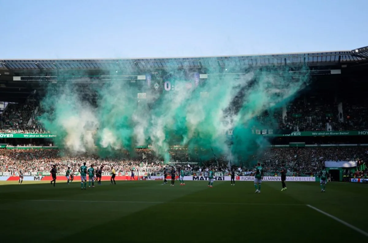 Green and white smoke flares come up from the terraces of Bremen's supporters during the German first division Bundesliga football match between SV Werder Bremen and FC Bayern Munich in Bremen, northern Germany on September 21, 2024.  Axel Heimken / AFP