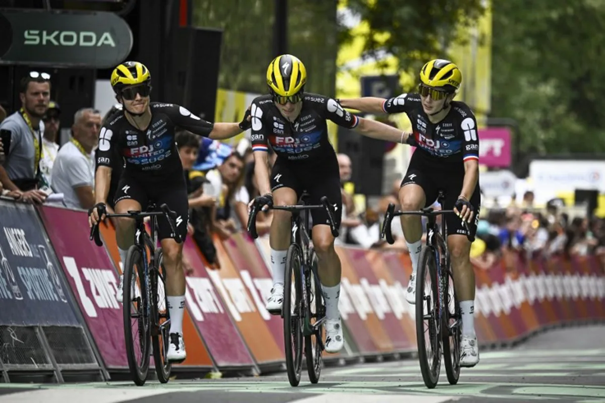 FDJ-SUEZ team's Dutch rider Demi Vollering (C) crosses the finish line as she is accompanied by her teammates FDJ-SUEZ team's Dutch rider Amber Kraak (L) and FDJ-SUEZ team's French rider Juliette Labous (R) after a fall during the 3rd stage (out of 9) of the fourth edition of the Women's Tour de France cycling race, 163.5 km from La Gacilly to Angers, in Angers, western France on July 28, 2025. The end of the stage 3 was marked by the heavy fall 3,700 meters from the finish line of the favorite of the event, the Dutchwoman Demi Vollering, who took time to get back up but was classified in the same time as the first competitors, the fall having occurred in the "sprint zone" of the last five kilometers. JULIEN DE ROSA / AFP