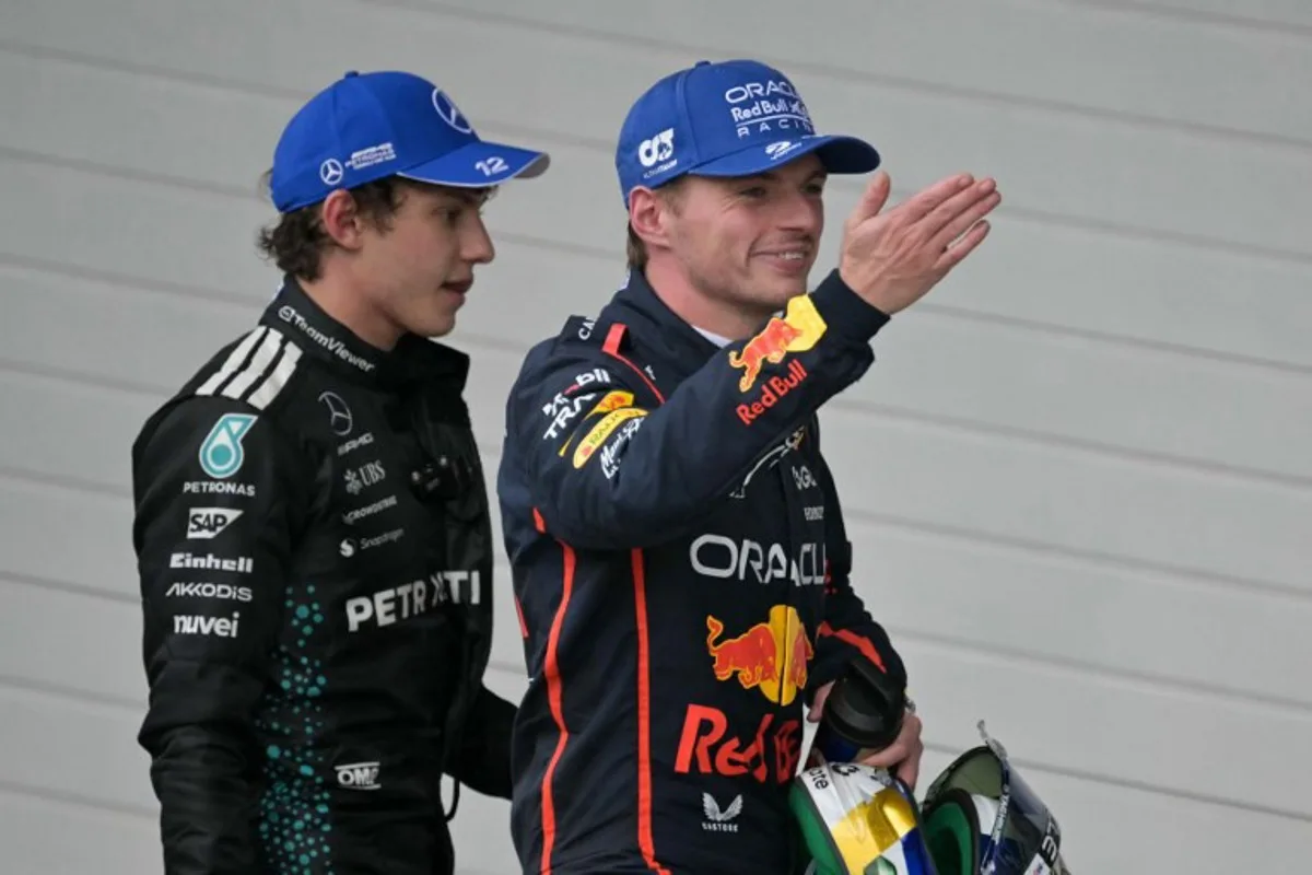 Red Bull Racing's Dutch driver Max Verstappen (R) smiles as he blows a kiss, next to Mercedes' Italian driver Kimi Antonelli (L), after getting the third place during the Sao Paulo Formula One Grand Prix at the Jose Carlos Pace racetrack, aka Interlagos, in Sao Paulo, Brazil on November 9, 2025. Nelson ALMEIDA / AFP