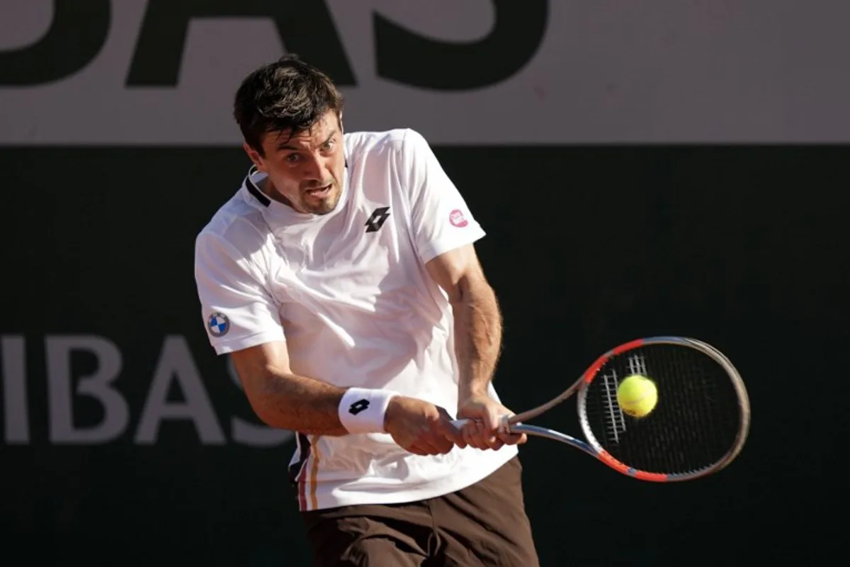 Austria's Sebastian Ofner plays a backhand return to Italy's Luciano Darderi during their men's singles match on day 3 of the French Open tennis tournament at the Roland-Garros Complex in Paris on May 26, 2026.  Dimitar DILKOFF / AFP