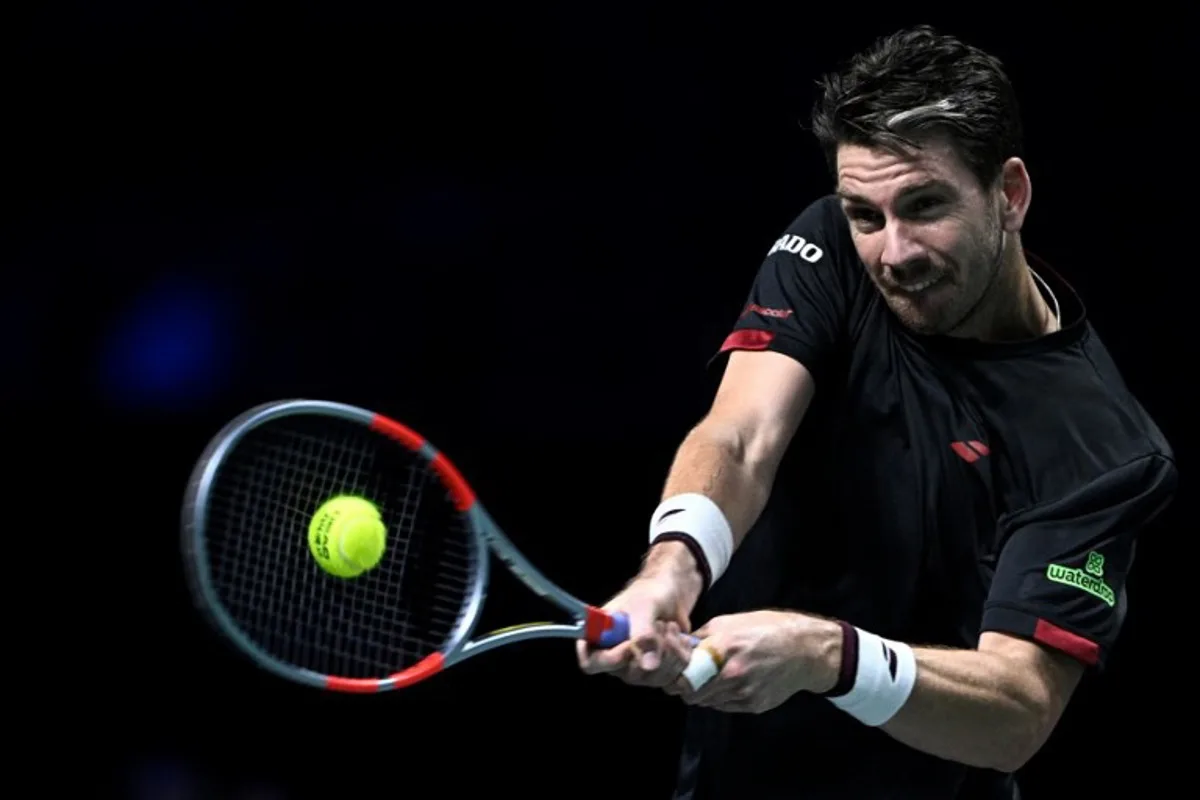 Britain's Cameron Norrie plays a backhand return to Monaco's Valentin Vacherot during their men's singles match on day four of the Paris ATP Masters 1000 tennis tournament at the Paris La Défense Arena in Nanterre, on the outskirts of Paris, on October 30, 2025. JULIEN DE ROSA / AFP