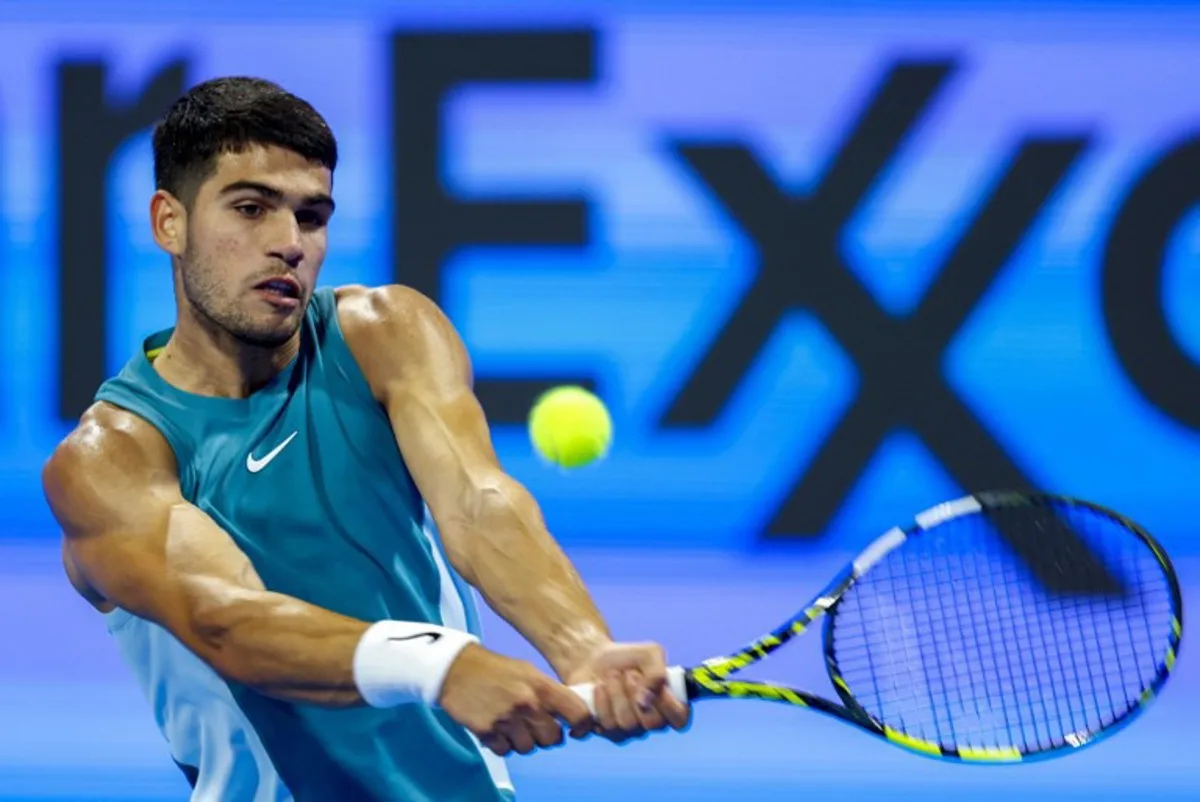 Spain's Carlos Alcaraz hits a return to Italy's Luca Nardi during their men's singles match at the ATP Qatar Open tennis tournament in Doha on February 19, 2025.  KARIM JAAFAR / AFP