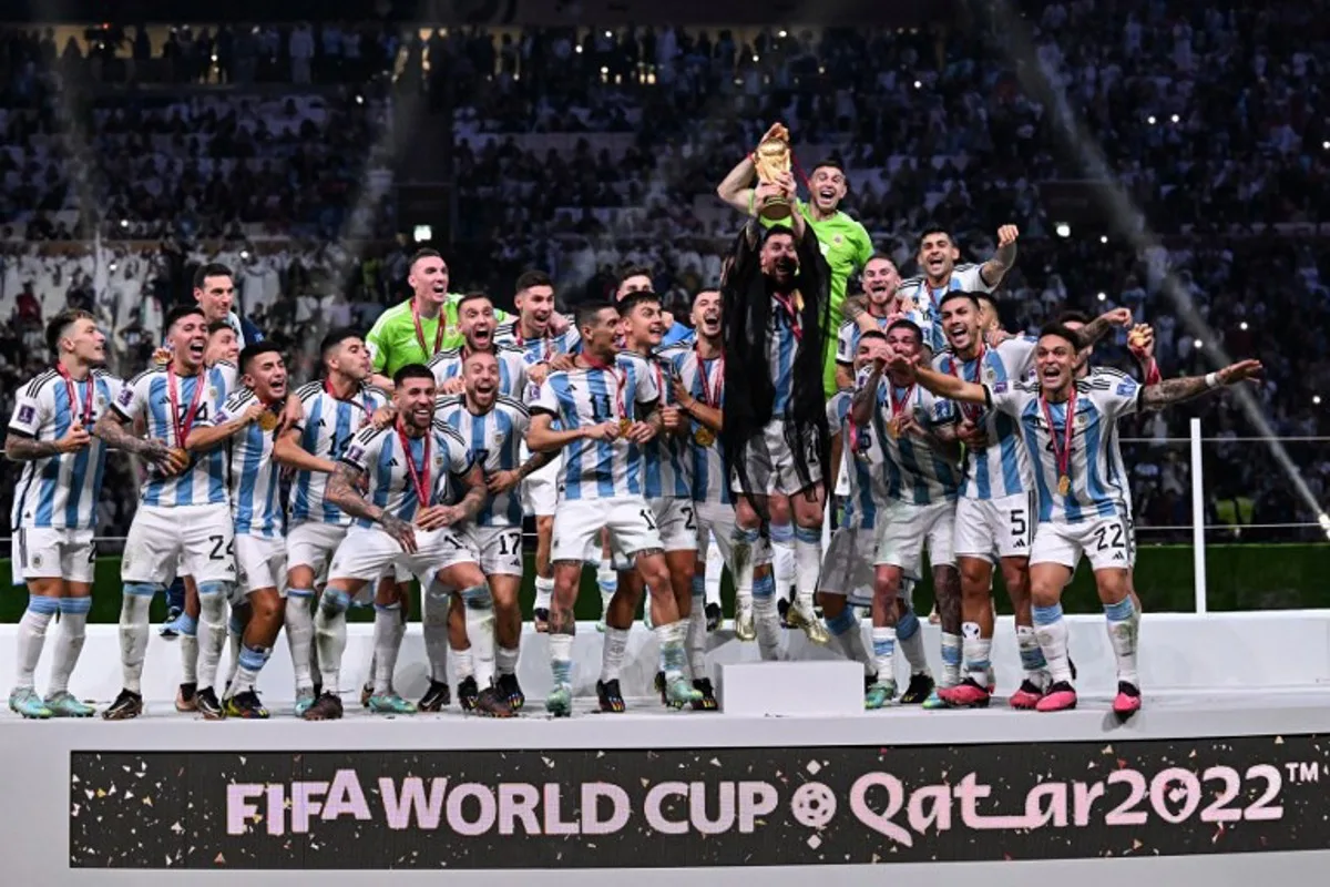 Argentina's forward #10 Lionel Messi (C) holds up the FIFA World Cup Trophy as he celebrates with teammates winning the Qatar 2022 World Cup final football match between Argentina and France at Lusail Stadium in Lusail, north of Doha on December 18, 2022.  Kirill KUDRYAVTSEV / AFP