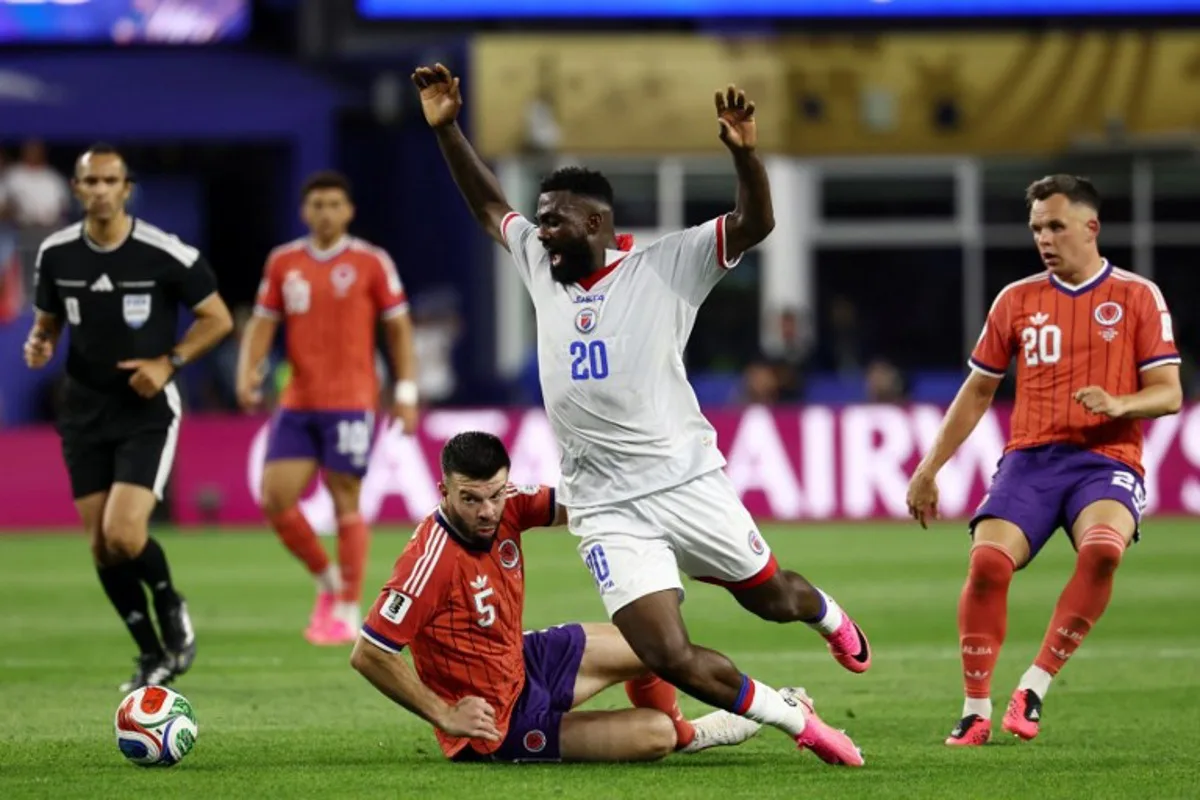 Scotland's defender #05 Grant Hanley and Haiti's forward #20 Frantzdy Pierrot fight for the ball during the 2026 World Cup Group C football match between Haiti and Scotland at the Boston Stadium in Foxborough on June 13, 2026.  FRANCK FIFE / AFP