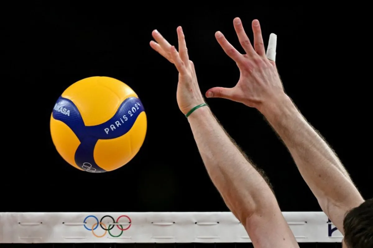 A Canadian player tries to block the volleyball during the men's preliminary round volleyball match between Slovenia and Canada during the Paris 2024 Olympic Games at the South Paris Arena 1 in Paris on July 28, 2024.  Andrej ISAKOVIC / AFP