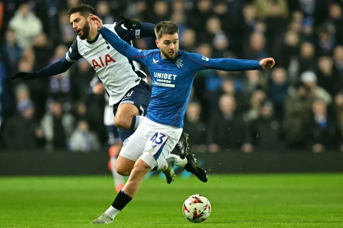 Rangers' Belgian midfielder #43 Nicolas Raskin fights for the ball with Tottenham Hotspur's Uruguayan midfielder #30 Rodrigo Bentancur during the UEFA Europa League, League Phase football match between Rangers and Tottenham Hotspur at the Ibrox Stadium in Glasgow on December 12, 2024.  ANDY BUCHANAN / AFP