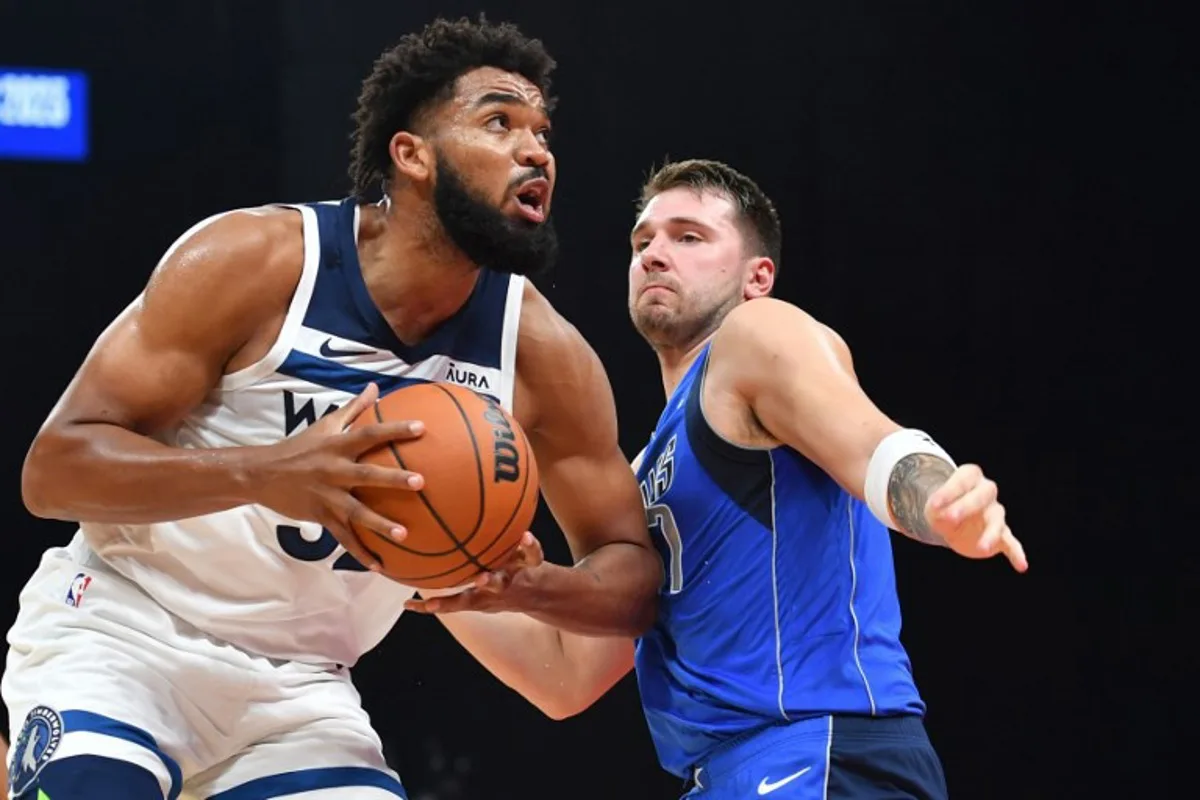 Dallas Mavericks' guard Luka Doncic #77 guards Minnesota Timberwolves' forward Karl-Anthony Towns #32 during the NBA Preseason game between the Dallas Mavericks and the Minnesota Timberwolves at the Etihad Arena in Abu Dhabi on October 7, 2023.  Ryan LIM / AFP