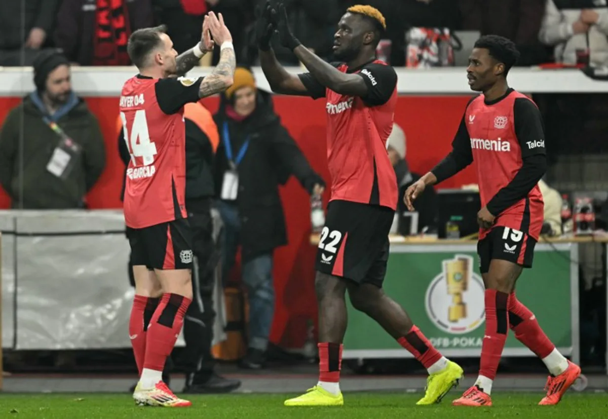 Bayer Leverkusen's Nigerian forward #22 Victor Boniface (C) celebrates scoring the 3-2 goal with his teammates during the German Cup (DFB Pokal) quarter-final football match  Bayer 04 Leverkusen vs FC Cologne in Leverkusen, western Germany on February 5, 2025.   INA FASSBENDER / AFP