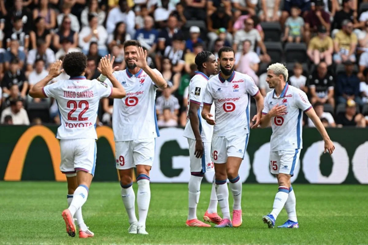 Lille's Portuguese defender #22 Tiago Santos (L) celebrates with teammates after scoring his team's first goal during the French L1 football match between Angers SCO and LOSC Lille at the Stade Raymond Kopa in Angers, western France on August 23, 2026.  Sebastien Salom-Gomis / AFP