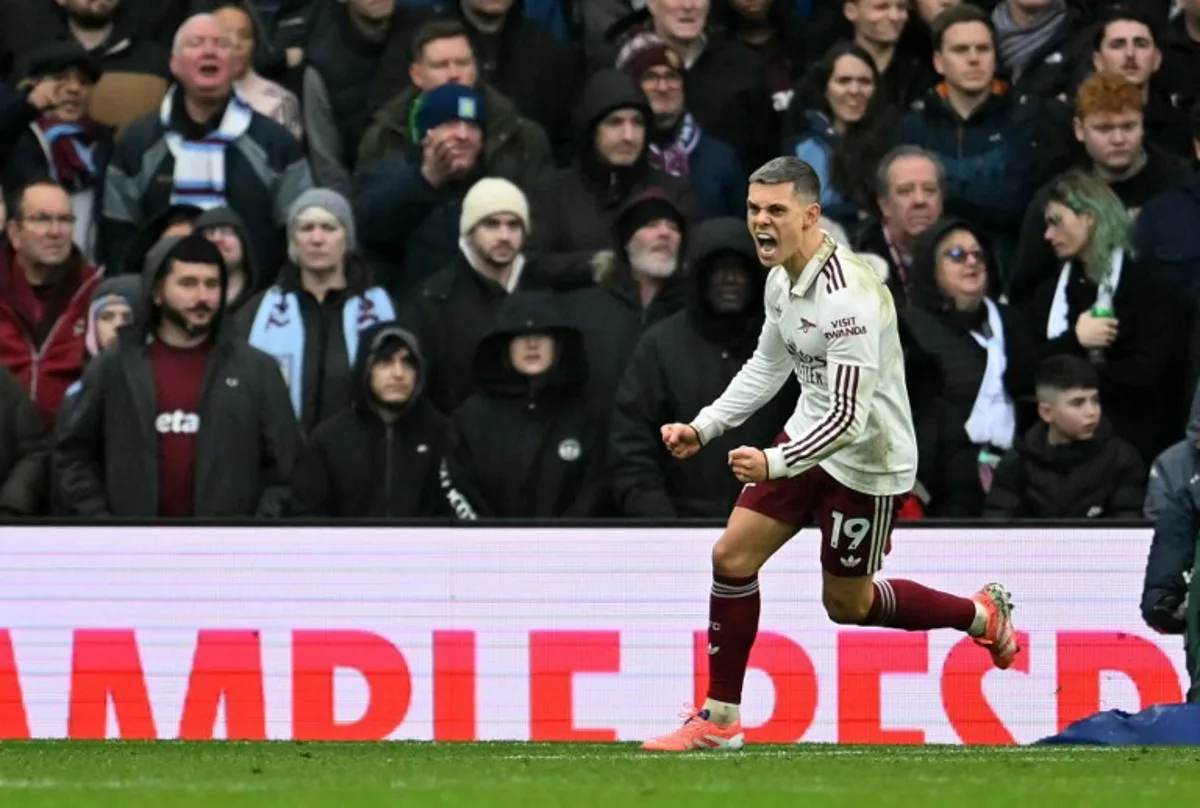 Arsenal's Belgian midfielder #19 Leandro Trossard celebrates after scoring the equalising goal during the English Premier League football match between Aston Villa and Arsenal at Villa Park in Birmingham, central England on December 6, 2025. JUSTIN TALLIS / AFP
