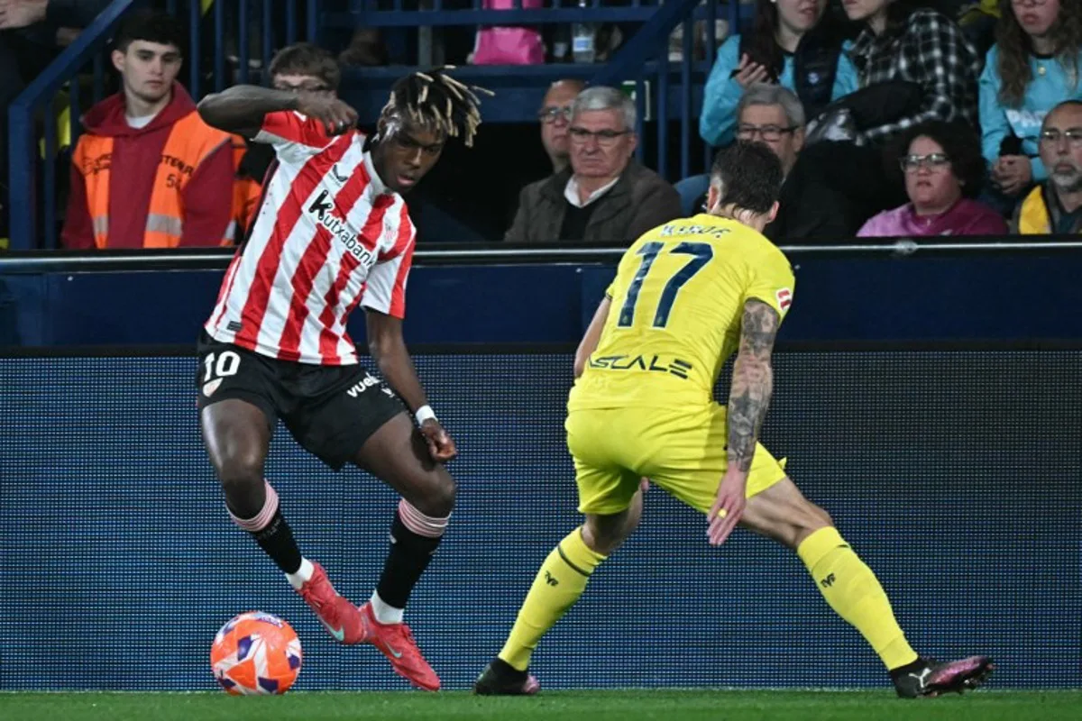 Athletic Bilbao's Spanish forward #10 Nico Williams and Villarreal's Spanish defender #17 Kiko Femenia vie for the ball during the Spanish league football match between Villarreal CF and Athletic Club Bilbao at La Ceramica stadium in Vila-real on April 6, 2025. JOSE JORDAN / AFP