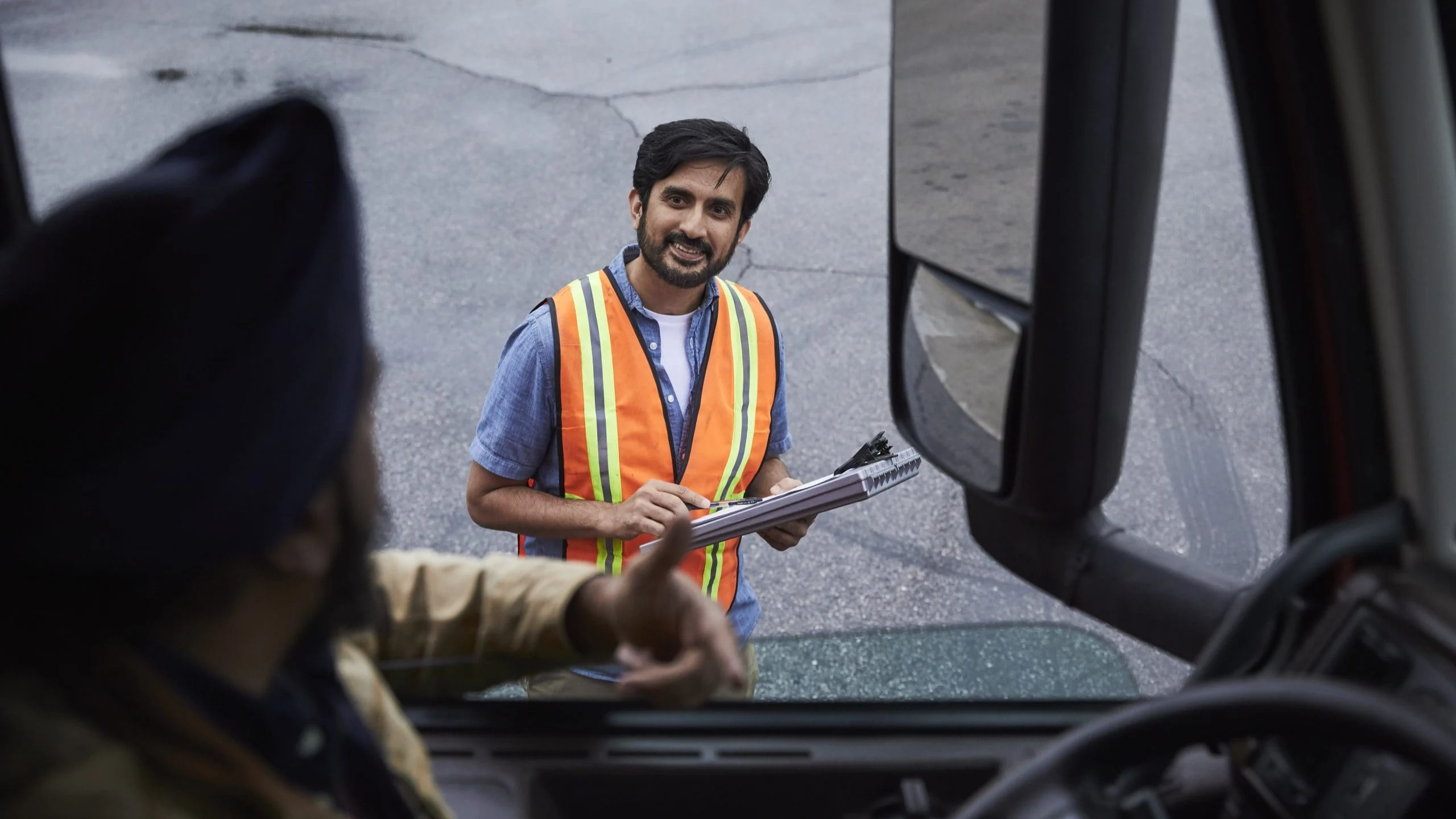 Man talking to man inside truck.