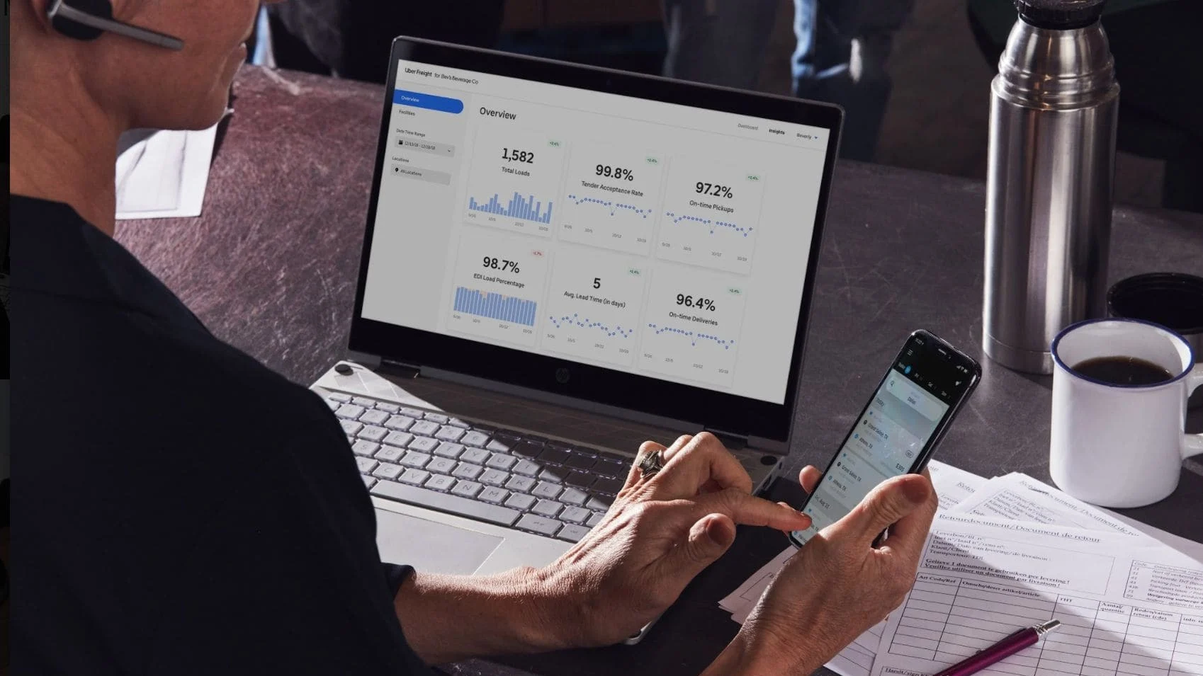 Person looking at shipping platform on phone and laptop.