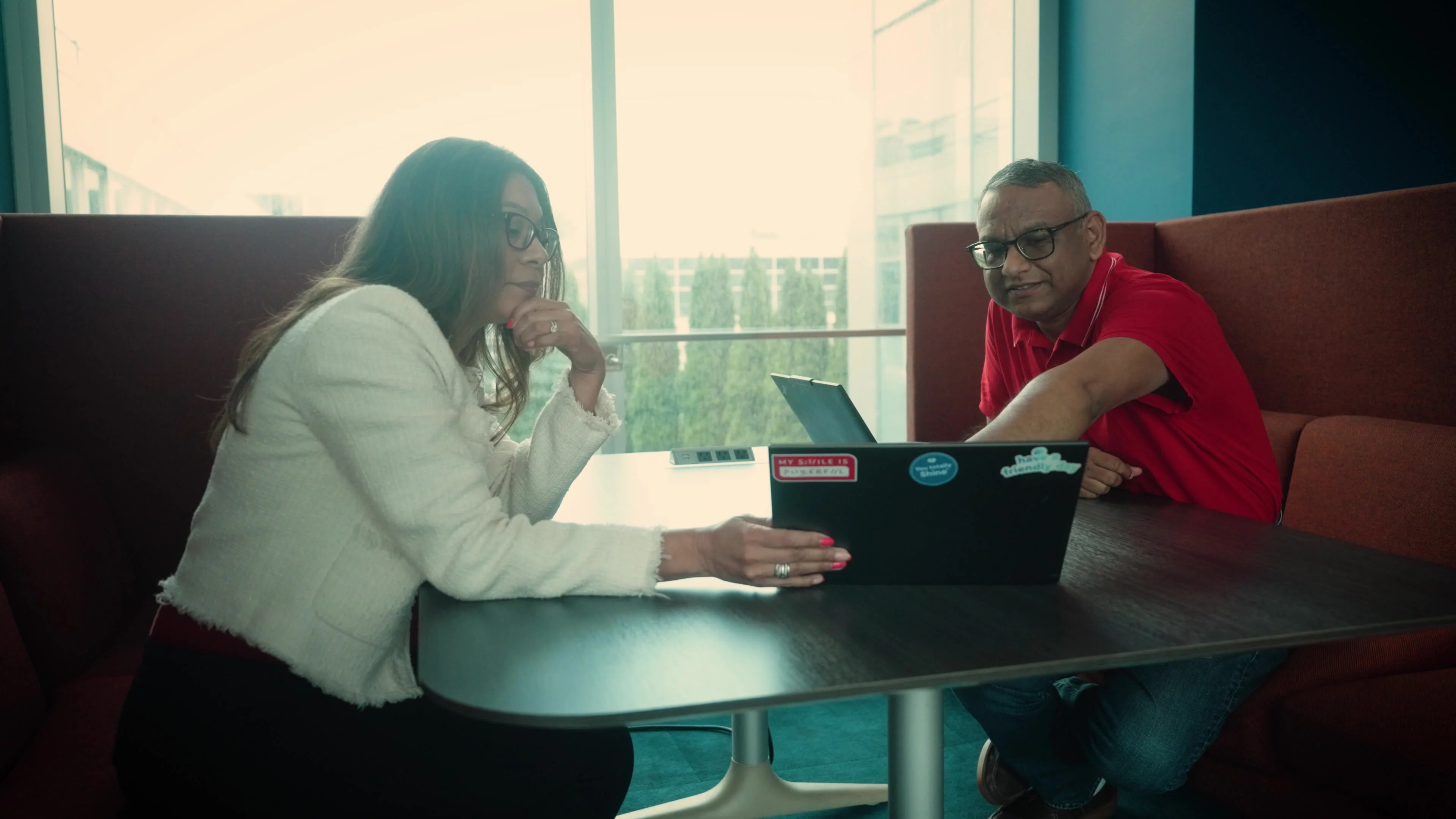 Colgate-Palmolive employees at a table looking at laptop