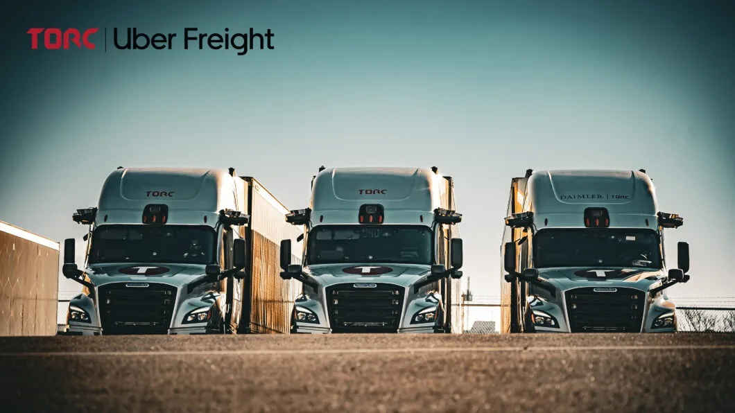 Three TORC semi-trucks parked side by side with Uber Freight branding displayed at the top of the image.