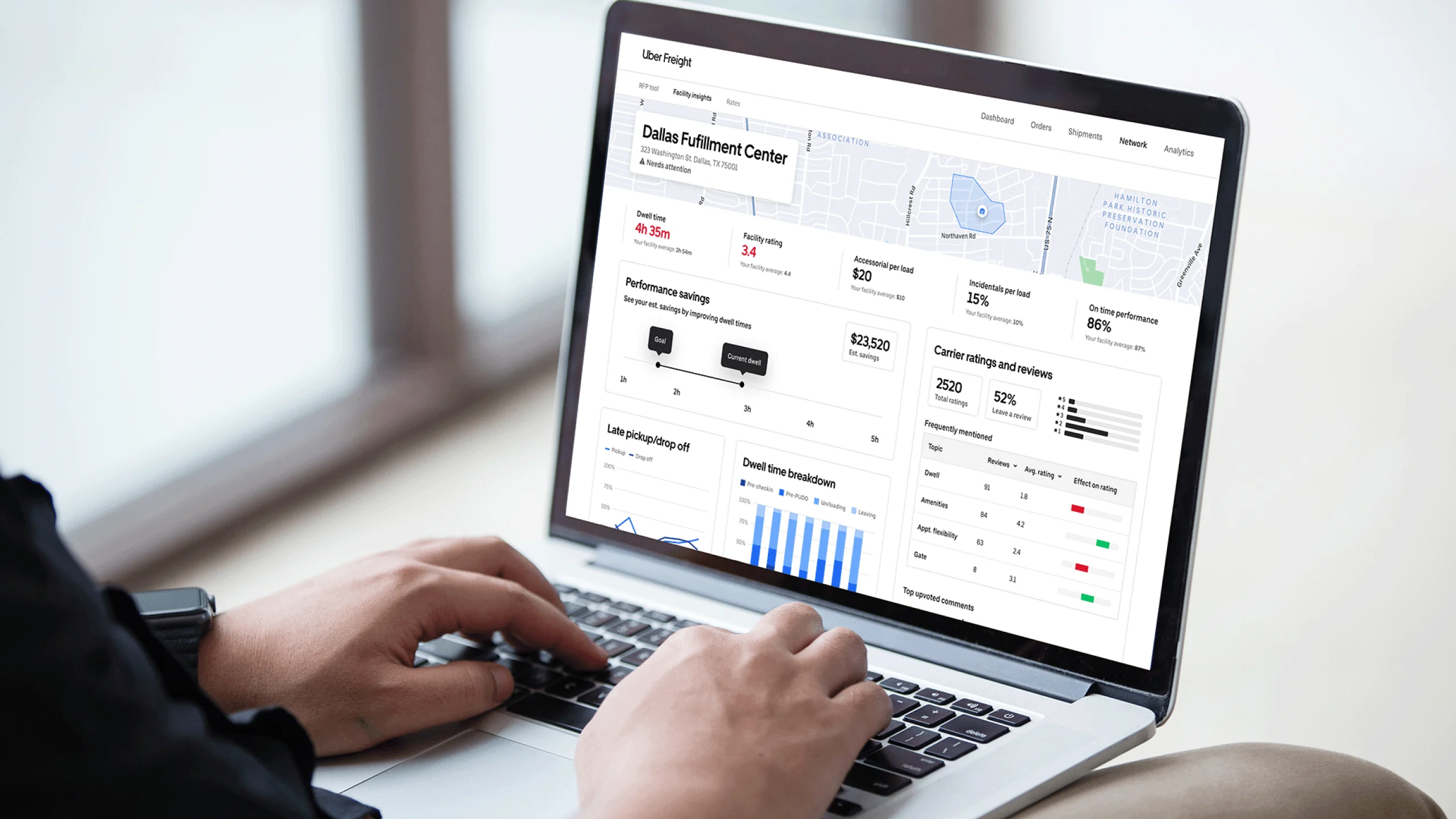 Person using laptop displaying Uber Freight dashboard with Dallas Fulfillment Center data, metrics, and performance analytics.