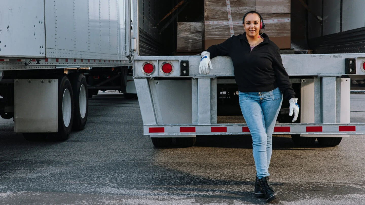 Woman standing behind truck.