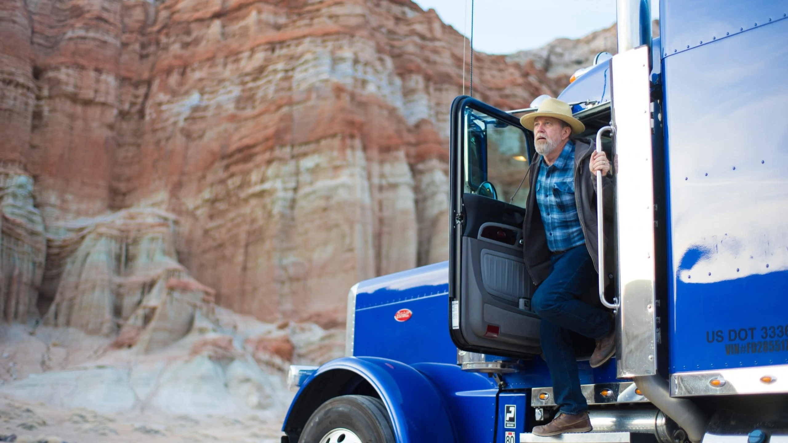 Man stepping out of a blue truck.