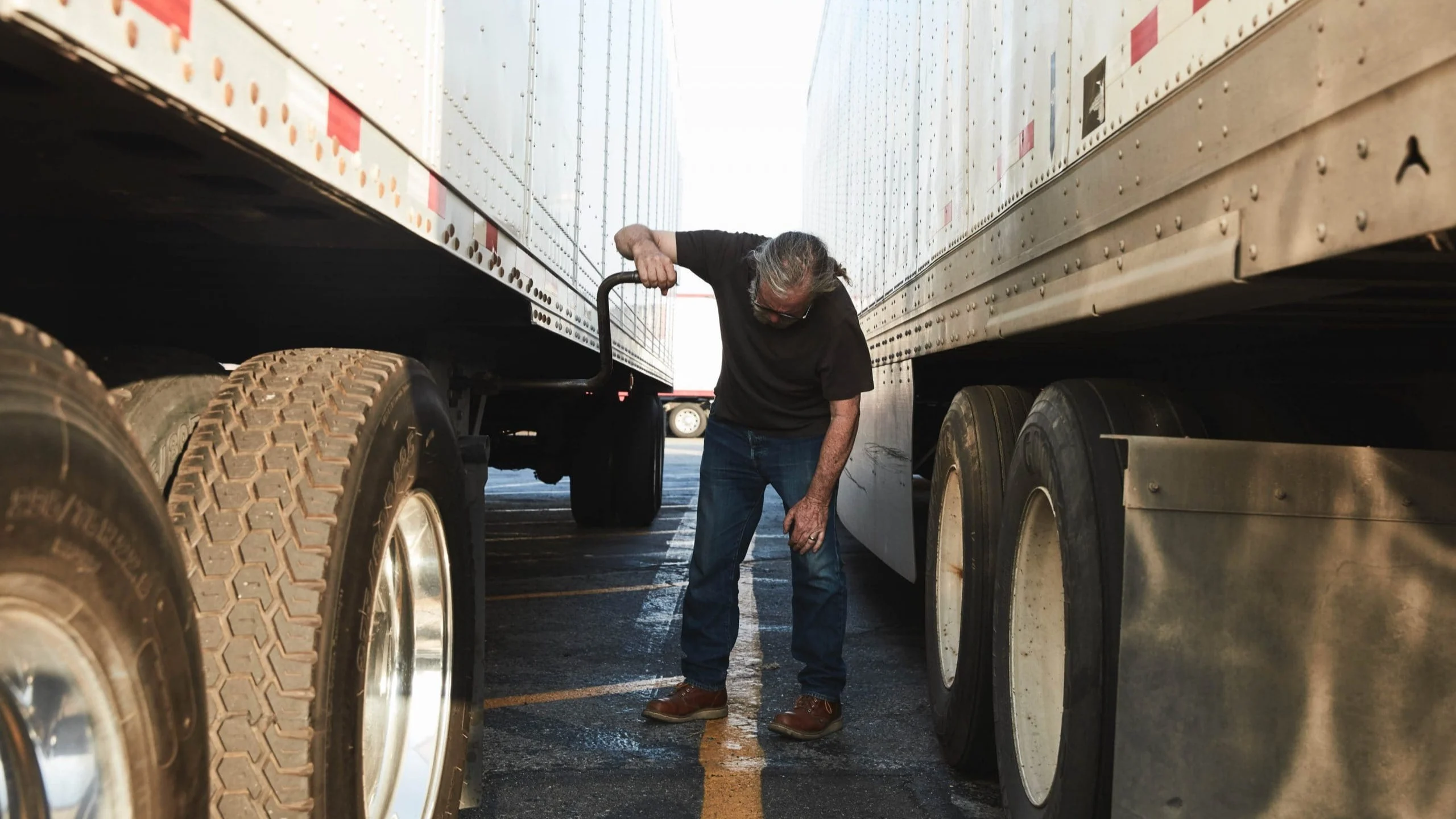 Man inspecting bottom of truck.
