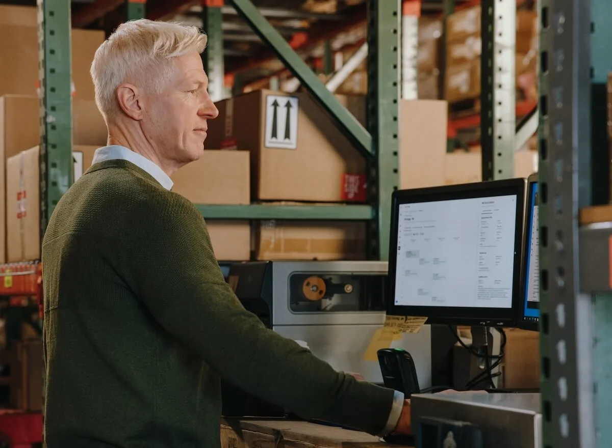 Responsable de la chaîne d'approvisionnement utilisant un logiciel de logistique 4PL à un terminal d'entrepôt pour optimiser les coûts de fret.