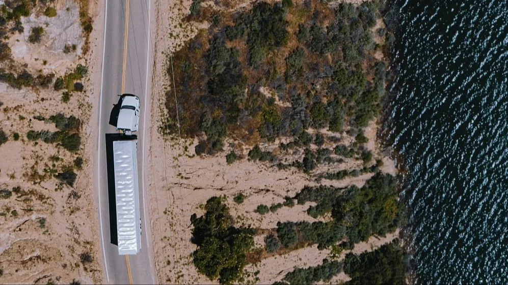 Truck on the road near water.