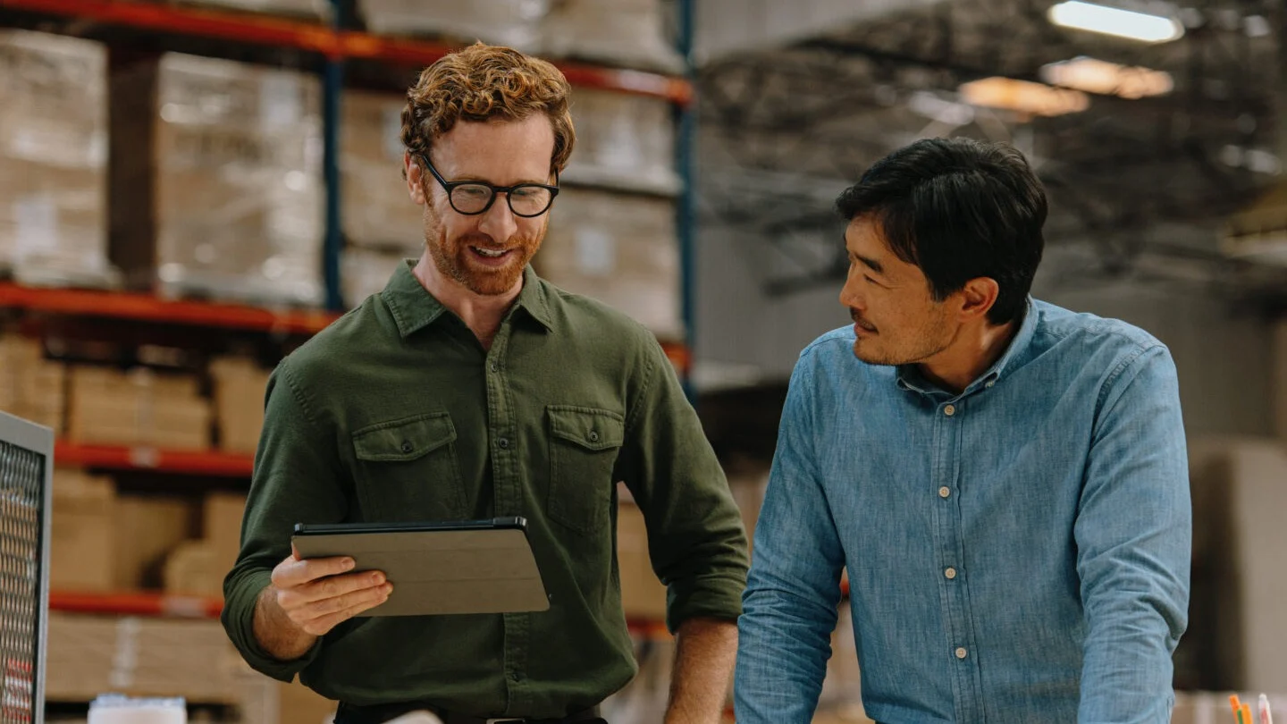 Two men having a discussion in a warehouse.