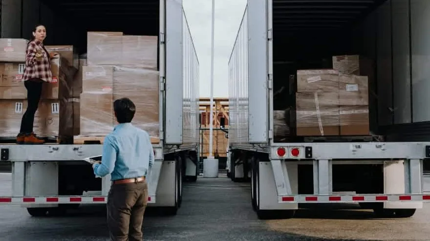 Man and woman having a conversation behind two open truck doors.